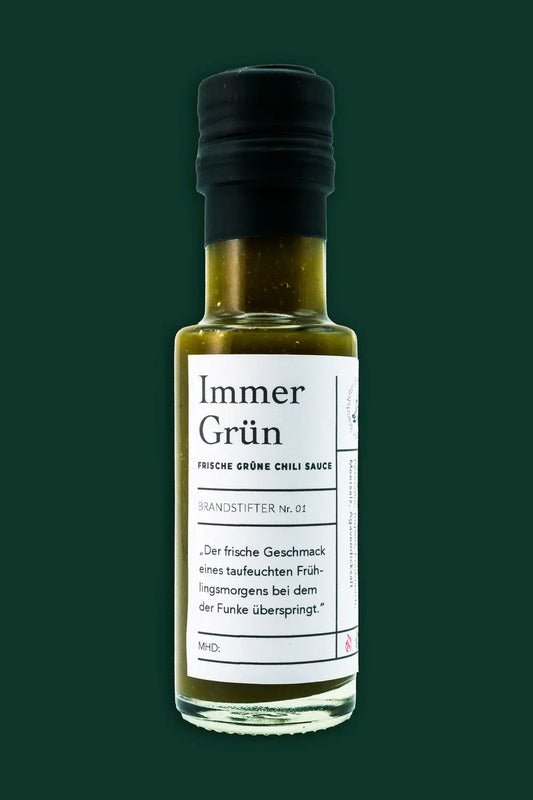 Grüne Chilisauce in Flasche vor Moosgrünem Hintergrund